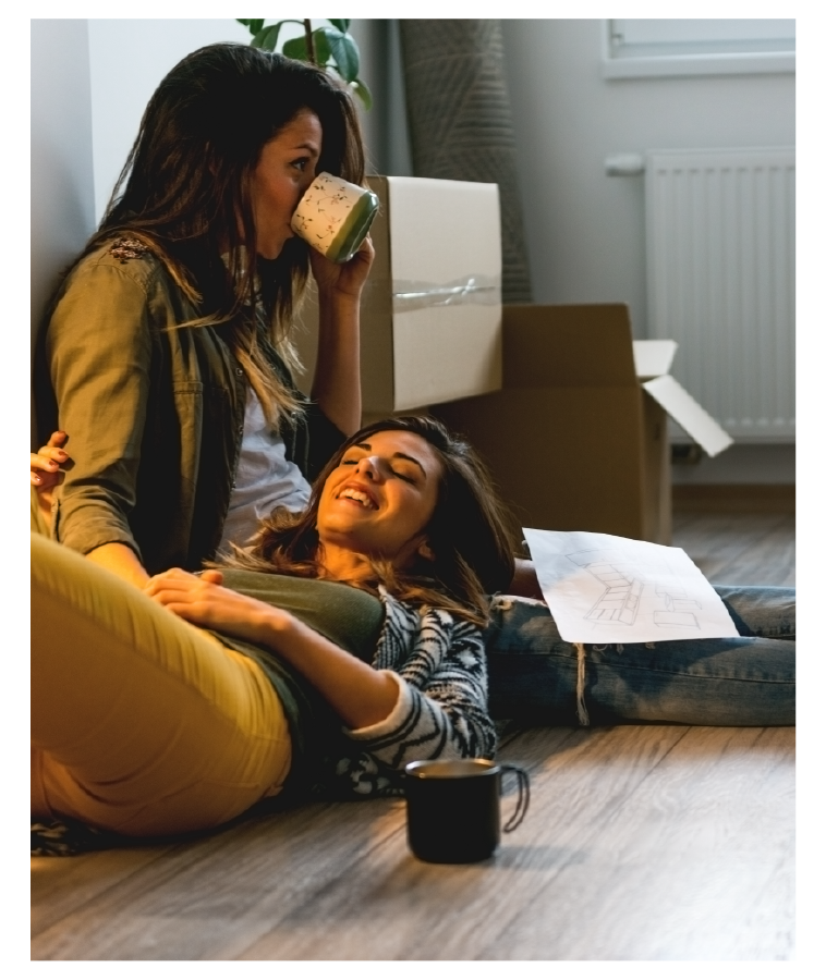 LGBTQ+ Couple laying on the floor drinking coffee